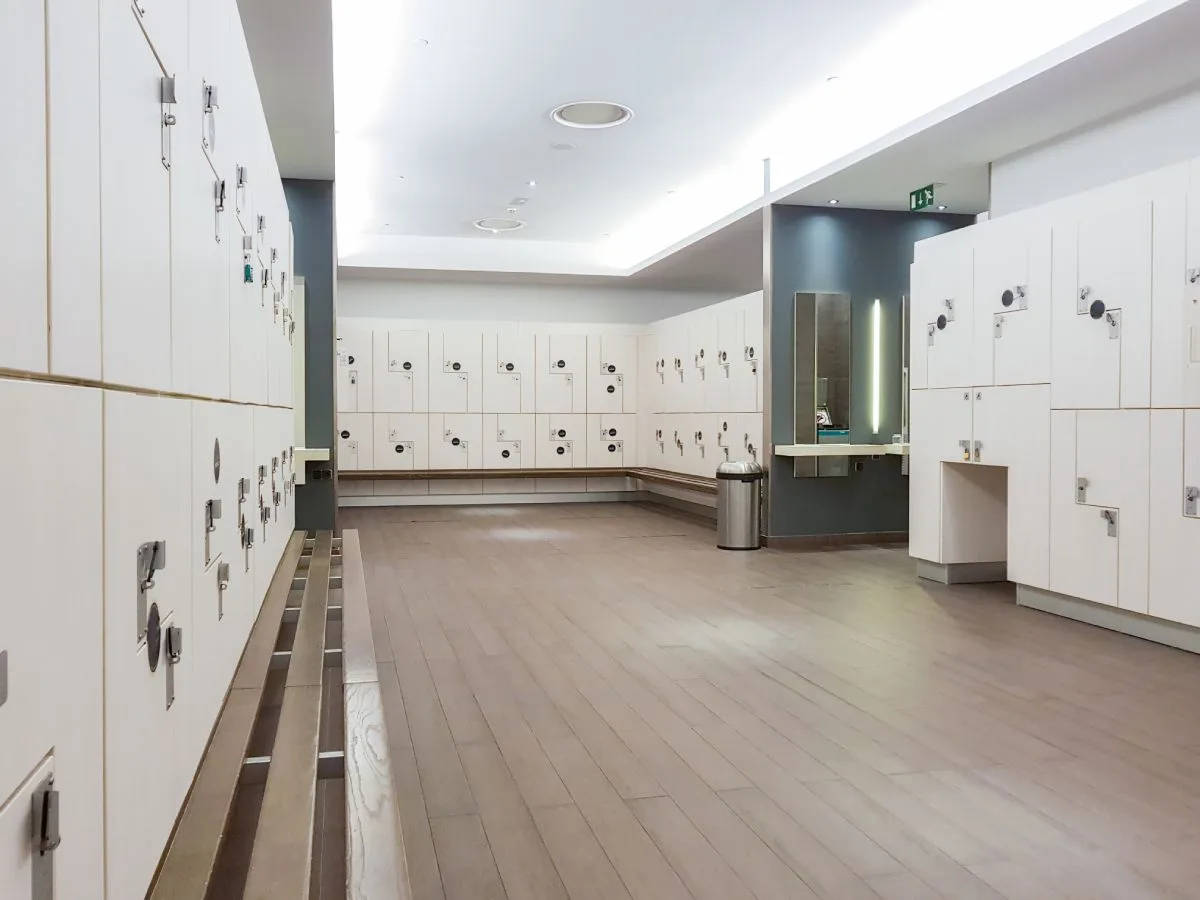 img-gym-locker-room Empty gym locker room with clean floors, showing results of a professional gym floor cleaning service.