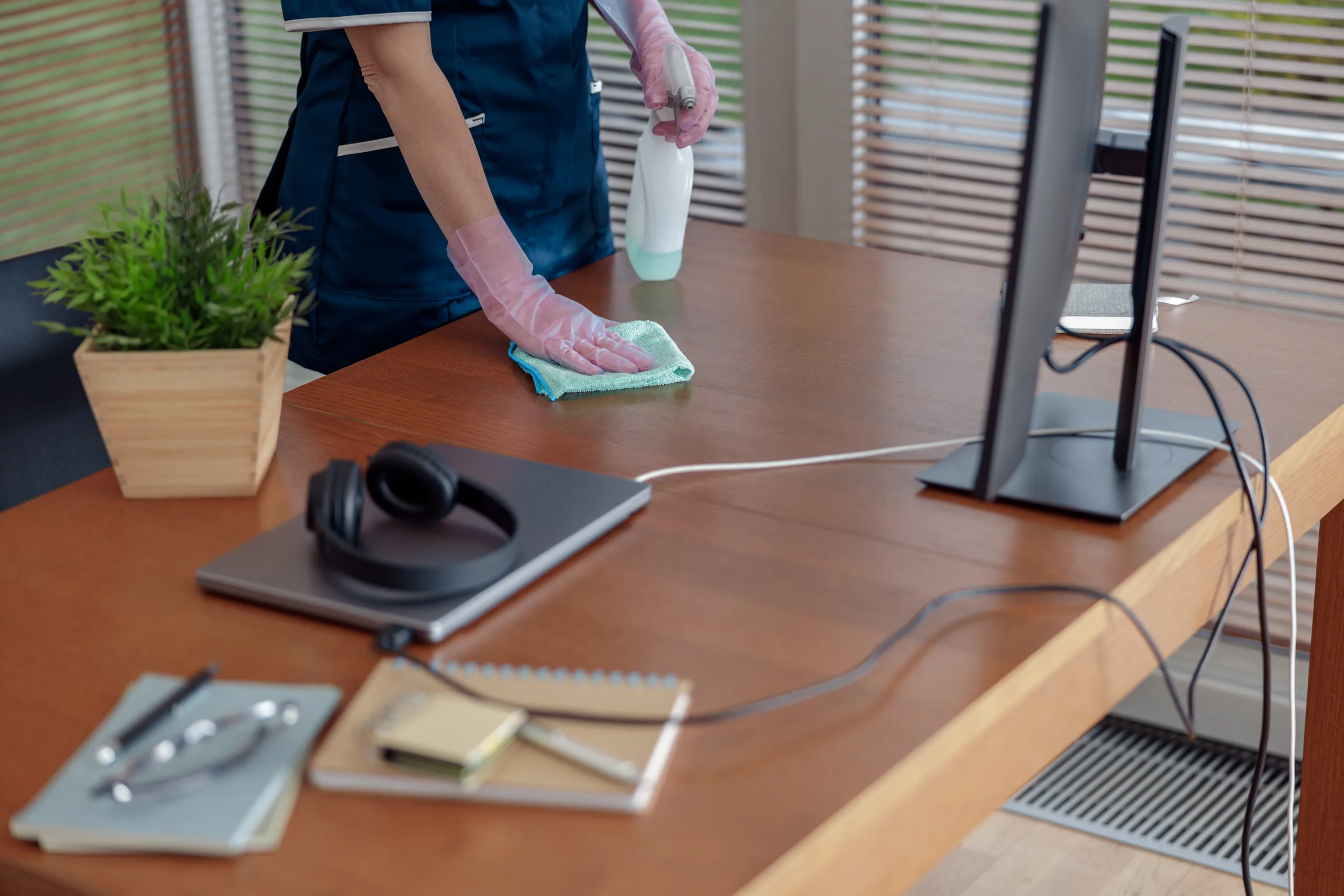 Close up of cleaning lady wiping dust off furniture in apartment. General or regular cleanup in room Meeting and workspace cleaning scaled