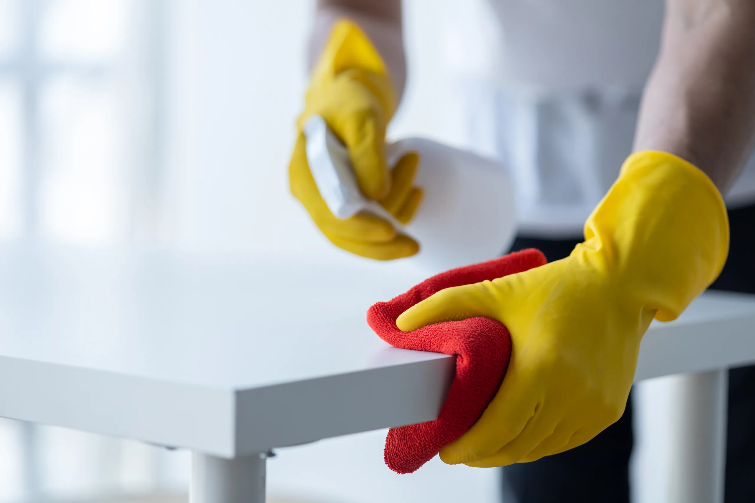 Person cleaning the room, cleaning staff is using cloth and spra dusting and surface cleaning scaled