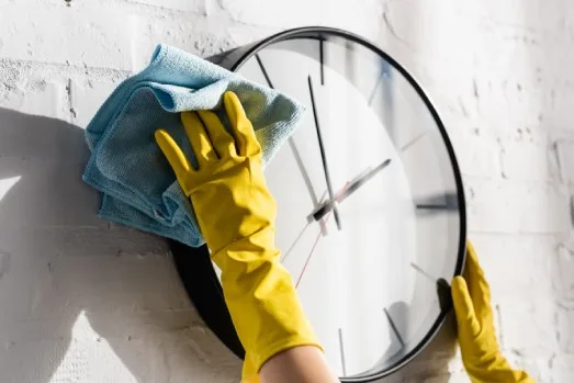 Cleaning a modern black-framed clock